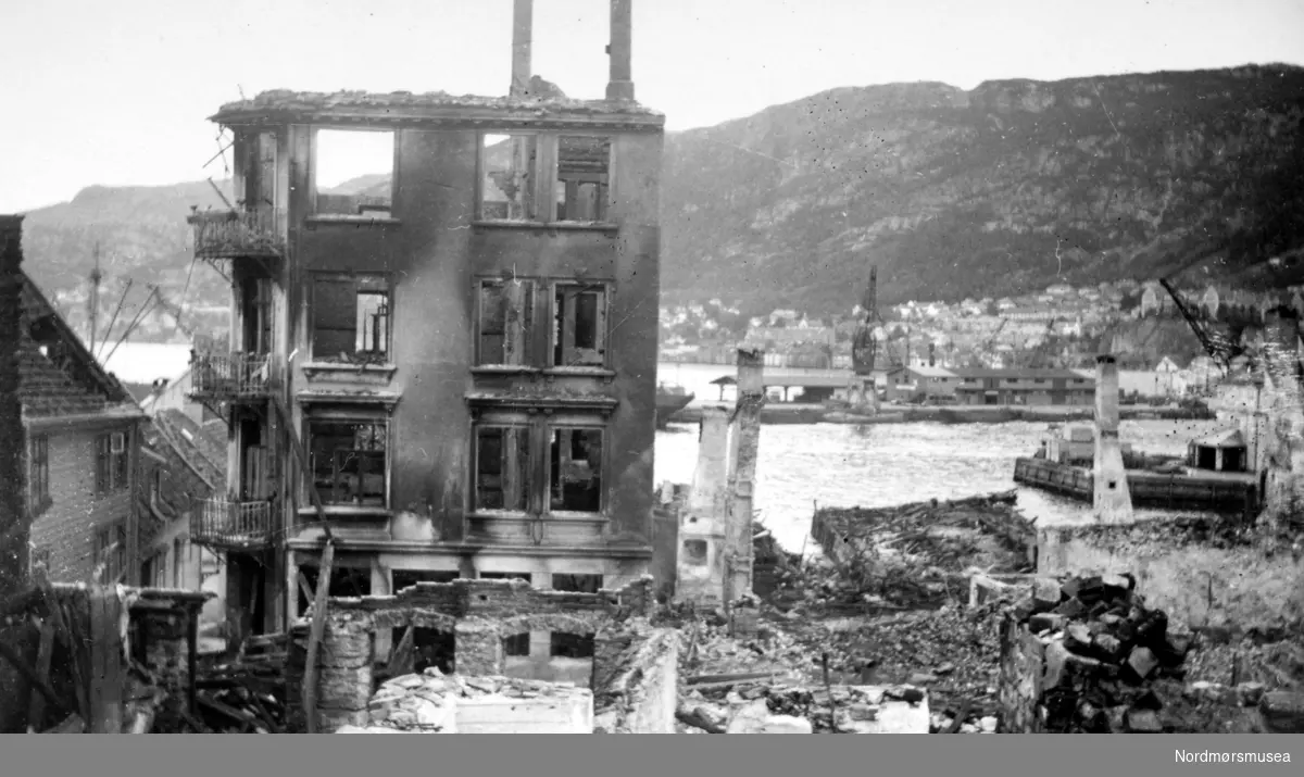 Foto fra et tettsted i ruiner. Kan det være fra brannen i Surna i Surnadal kommune i 1938, eller er det fra krigen noen år senere og en annen plass i Møre og Romsdal? Datering er ukjent, men muligens omkring 1938 til 1943. Se serie fra reg. nr. KMb-1987-005.2923 til KMb-1987-005.2941.

Tyskernes bombing av Bergen i juni 1940.
 Fra Nordmøre museums fotosamlinger.
