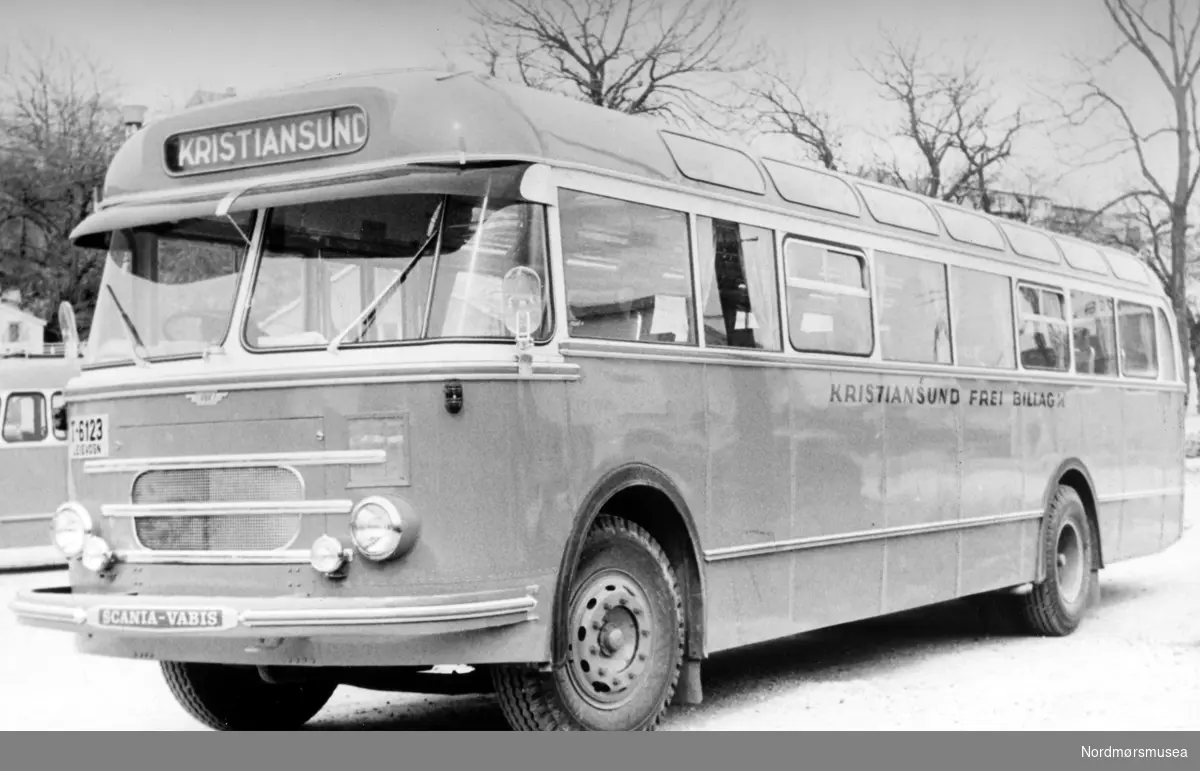 Bussen er registrert T-6123 og var en Scania-Vabis B71 personbuss med 40 sitteplasser. Karosseriet ble levert av Vestfold Bil og Karosseri (VBK). Bussen er 1958-modell og ble registrert 10. mai 1958. Bussen var i bruk til 1972. Det var Kristiansund Frei Billag som hadde bussen i trafikk. Bildet er derfor tidligst fra 1958. (Info: Sveinung Berild - 15.10.2016)   en av de lokale rutebussene i Kristiansund. Allanhagen. Fra Nordmøre museums fotosamlinger.