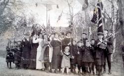 Foto trolig fra en 17. mai, hvor vi ser en gruppe men kvinne