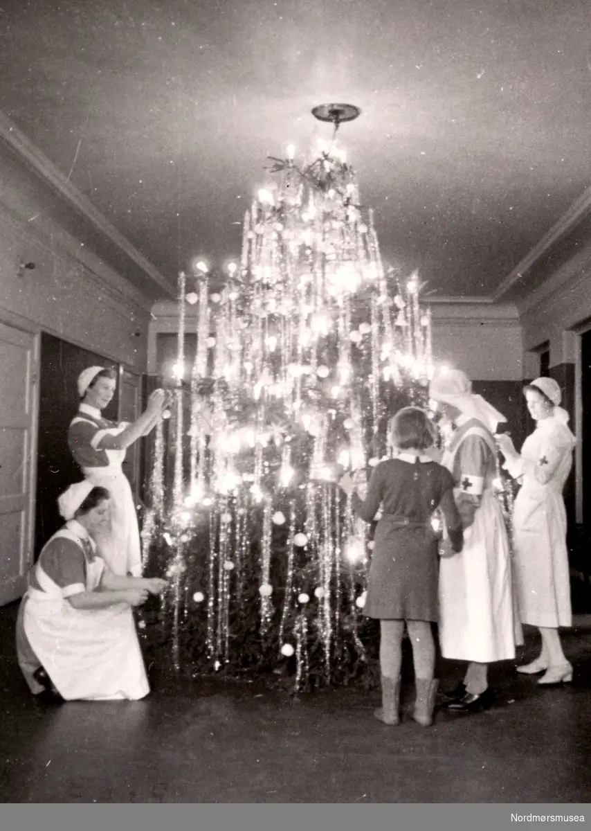 Julestemning, trolig desember 1943. Her ser vi en rekke sykepleierstudenter i gang med å pynte et juletre. Bildet er trolig fra Oslo, og elevene holder til ved Røde Kors' søsterhjem. Fra Ida M. Knudtzons fotosamlinger, nå en del av Nordmøre museums fotosamlinger.