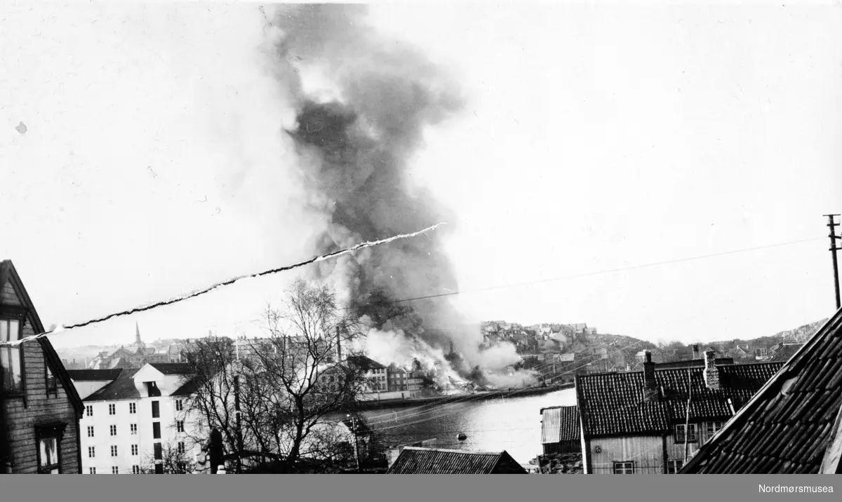 Bombingen på Kirkelandet sett fra Th. Aasgaards gate /Hønebukta på Innlandet. Fra Nordmøre Museum sin fotosamling. EFR2015