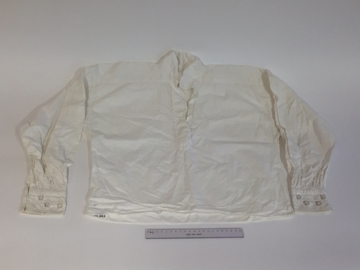 Lue, bryststykke/bringeduk og belte (C) til hardangerbunad, forkle (E) og skjorte (D) med hardangersømdetaljer.