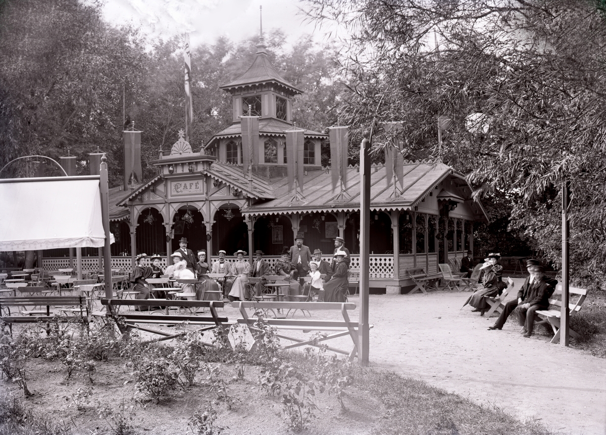 Bild tagen i Karlstad, eventuellt vid Värmlands Hushållningssällskaps utställning i Klara 1895 och visar i så fall cafpaviljongen i Våxnäsparken. I sällskapet syns J P Nyström, ägare till orgelfabriken med samma namn.