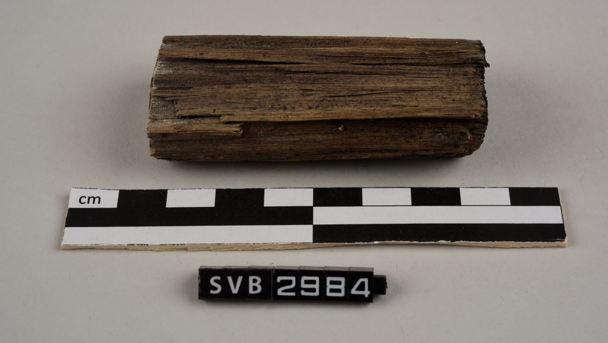 Tregjenstand med tilnærmet rundt tverrsnitt. Tremateriale er tørt og sprukkent. Det er 2 løse deler. Det er en lapp på undersiden med russiske tall og bokstaver.