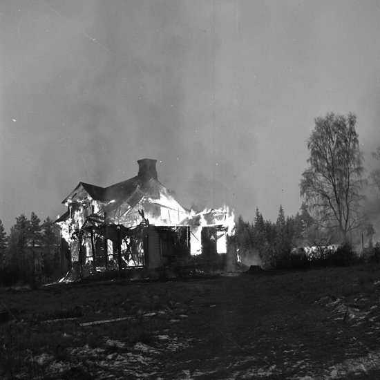 Foto av en brinnande mangårdsbyggnad.