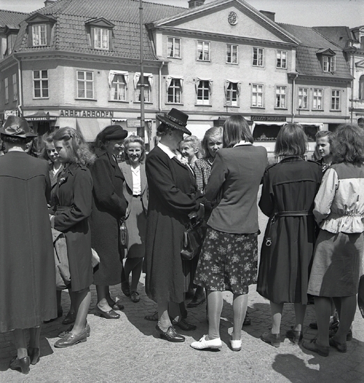 Betplockarna, 1942. 
Tonårsflickor pratar med varandra på Järnvägsplanen framför järnvägsstationen i Växjö, innan avfärd.