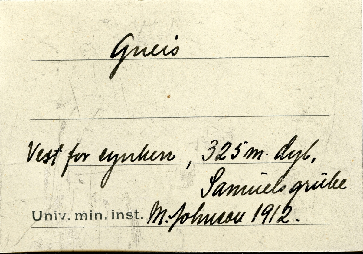 Etikett i eske:
Gneis
Vest for synken, 325 m. dyb,
Samuels grube
M. Johnson 1912.

+ papirlapp