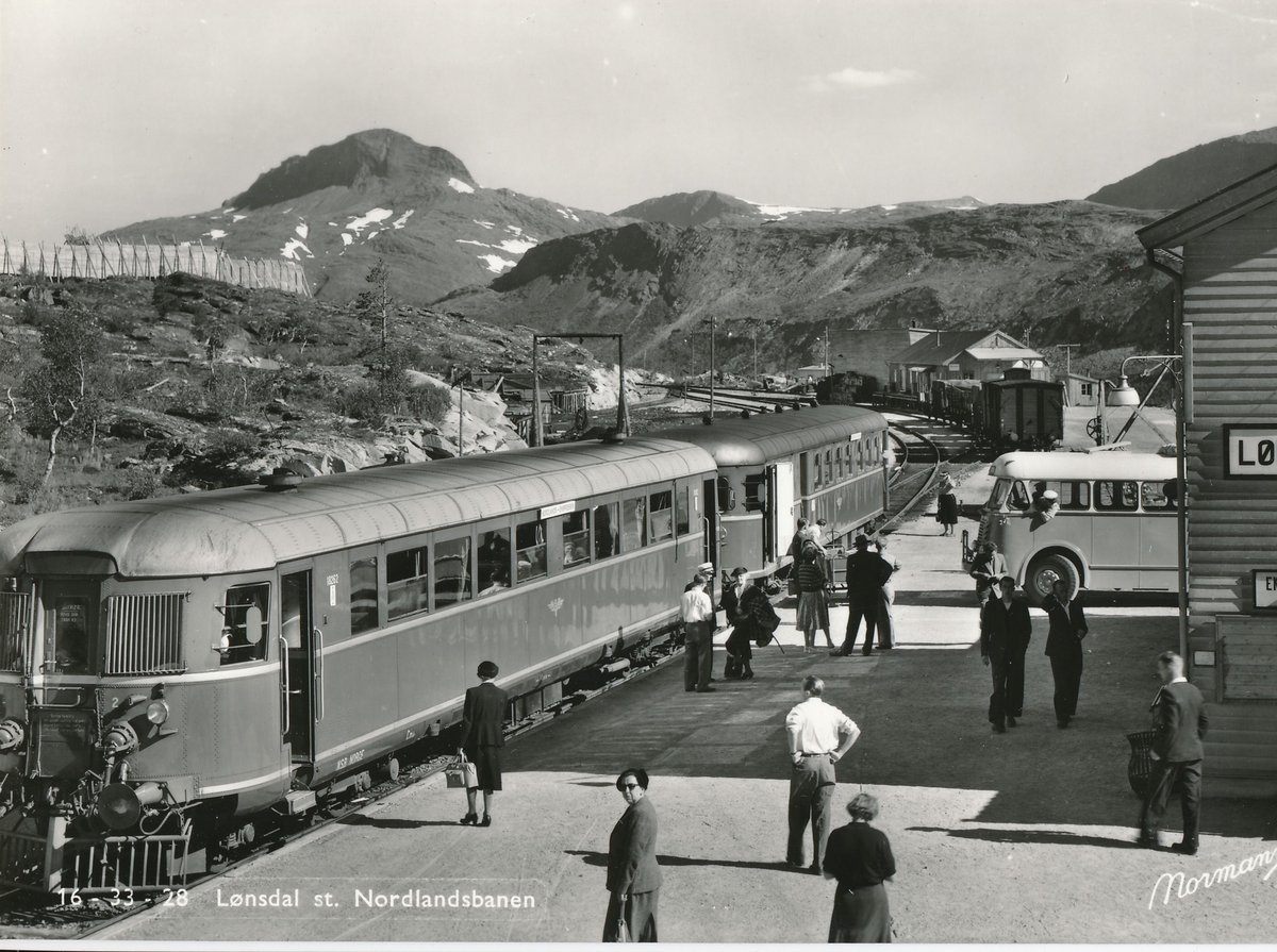 Lønsdal stasjon med reisende fra "Nordlandsekspressen" og ventende buss. Dieselmotorvogn type 6 nr. 18262.