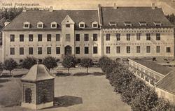 Postkort. Den nye museumsbygningen med torget i forgrunnen. 