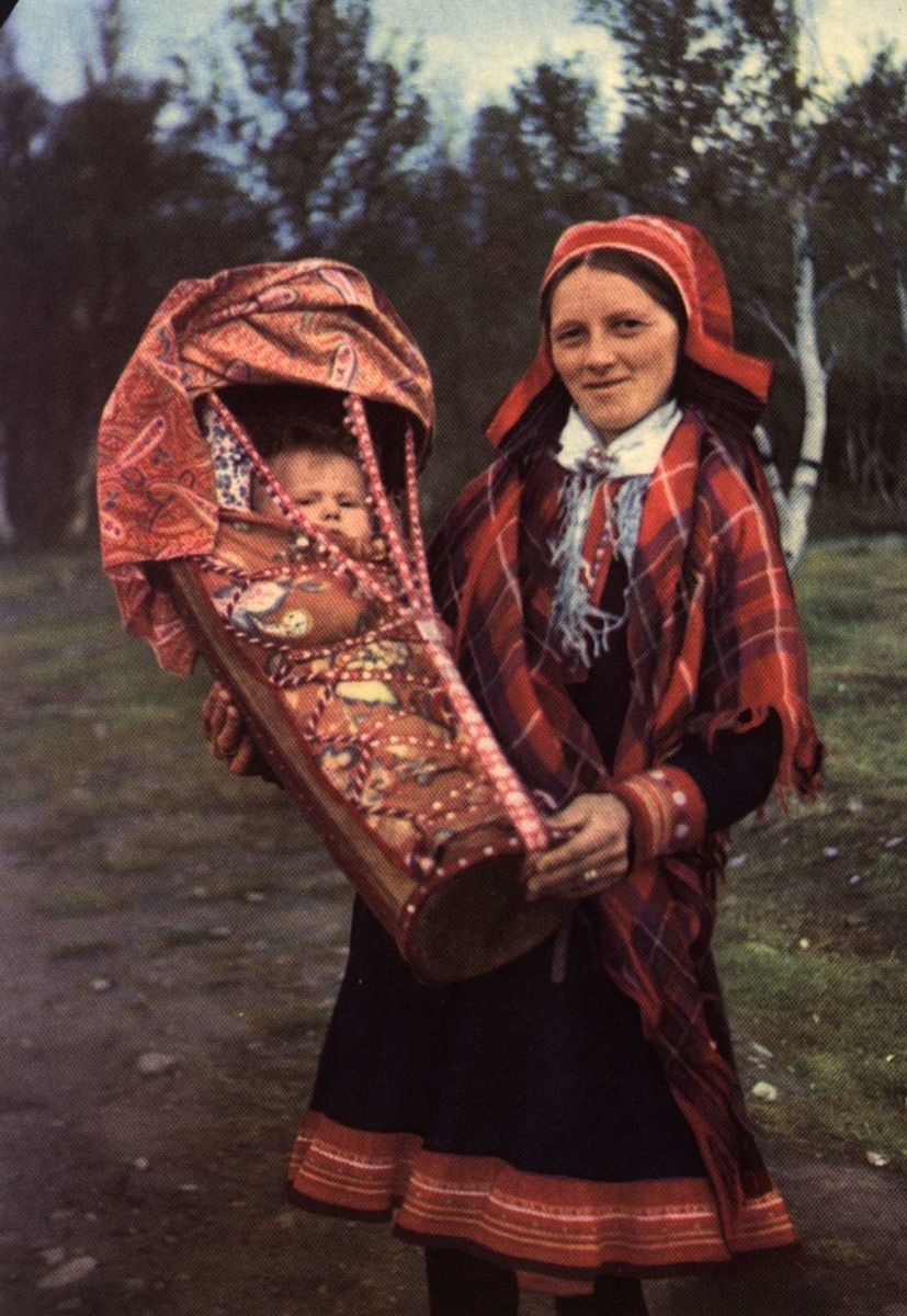 Postkort,  Norsk Folkemuseum. Samisk kvinne med spedbarn i kumse.