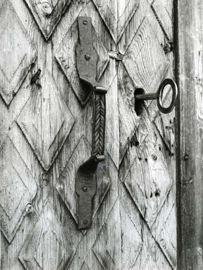 Detalj av en ytterdörr med handtag och nyckelhål med nyckel.