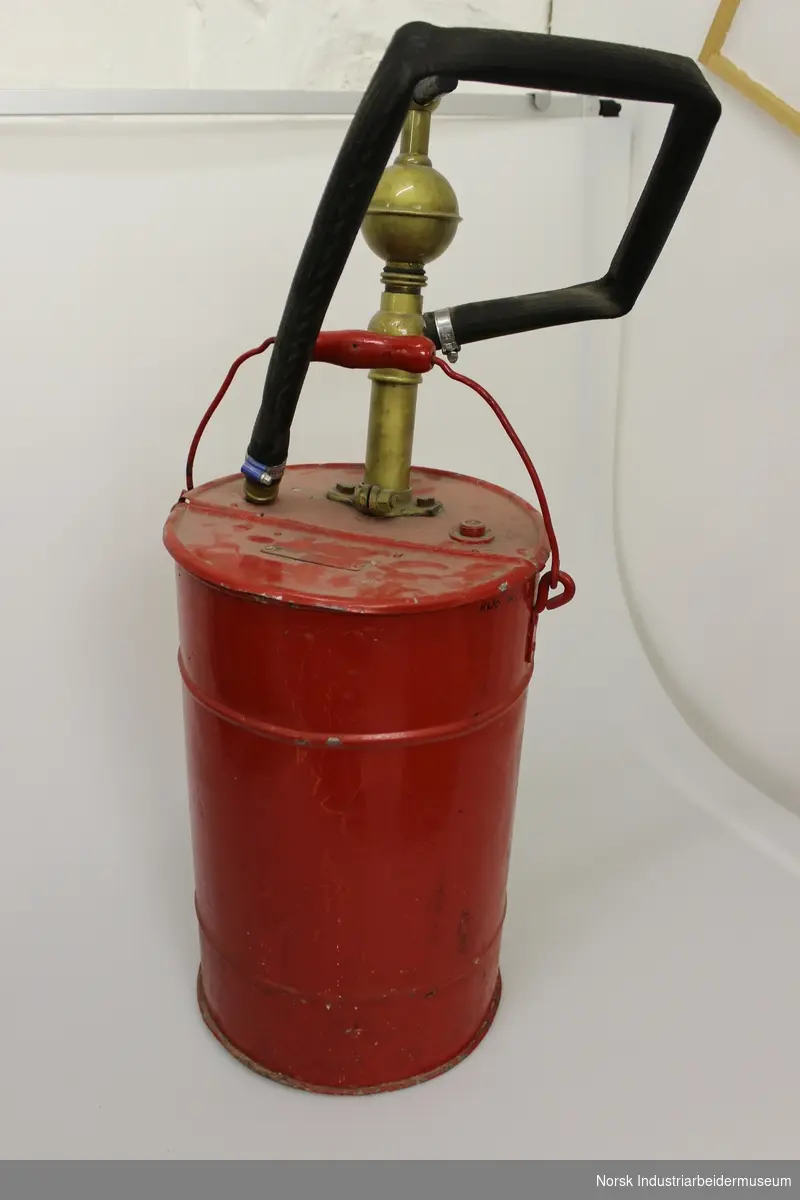 Et rødt sylinderformet brannapparat med messing håndtak og sort slange