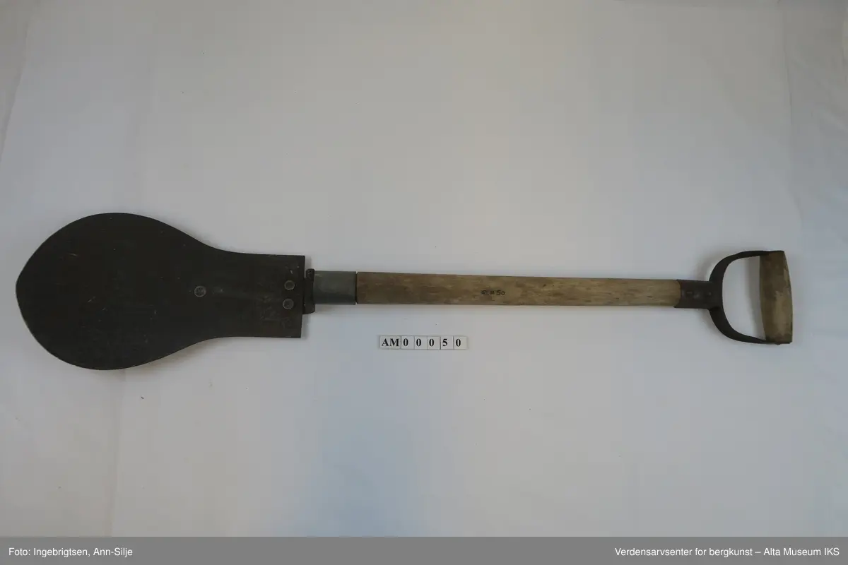 Form: Spaden har pære-formet blad med skaft i tre. Håndtaket er i metall og tre-