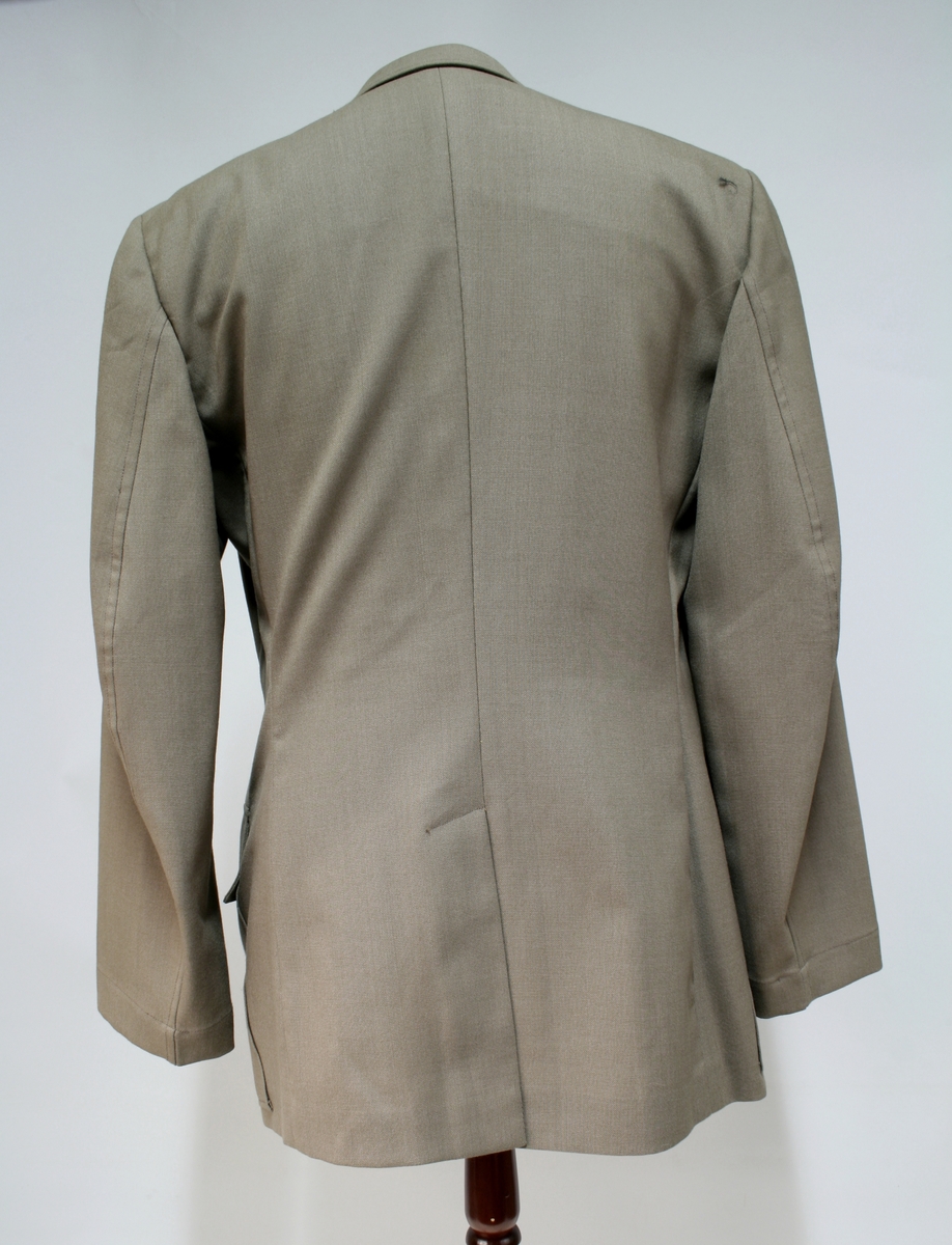 Modellen er lik 1953 modellen bortsett fra at den ikke har rett ryggsøm.

Khaki jakke med fire knapper, fire ytterlommer, kragespeil med riksløven av metall og skulderklaffer av sorte fletter.