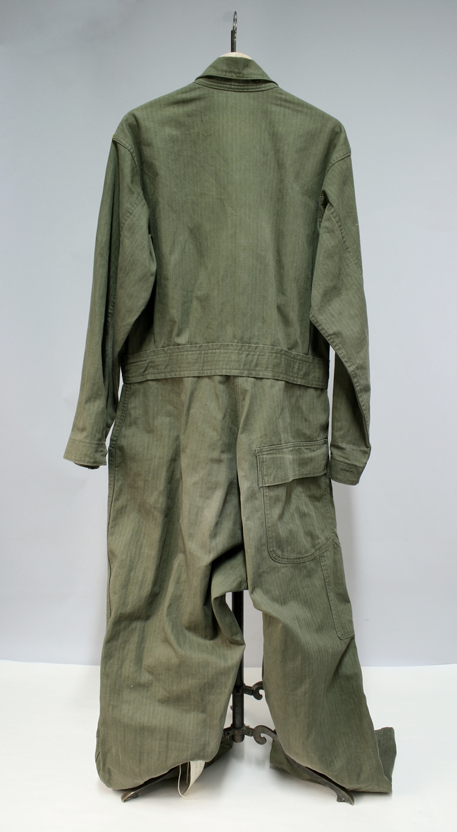 Militærgrønn kjeledress/overall med politimerking på brystet. Knappene tyder på at dressen er produsert i USA.