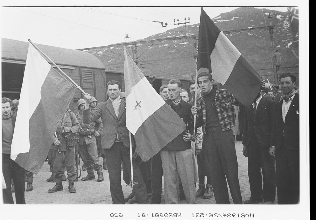Narvik stasjon. R P marsjerer inn i byen ( står bak på bilde ), forskj. flagg. Frigitte fanger.