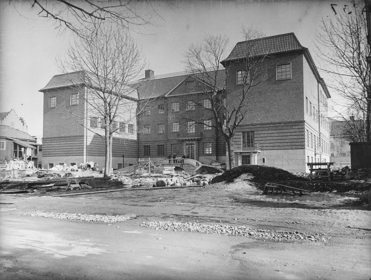 Bild tagen i samband med arbetet att uppföra Gävle Museum åren 1938-40. Området framför museet är ännu ej iordningsställt. Till vänster det rivningsfärdiga huset mot Södra Centralgatan.