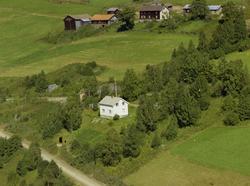 Bergseth. Hvitmalt bolighus med hage og store trær rundt.
Å