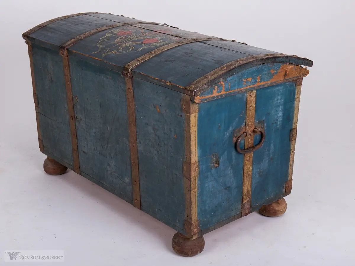 Rosemaling på blå bunn.  Det midtre feltet er dekorert med symetrisk rosemaling på blå bunn . I de to andre feltene på fronten er malt med initialene.