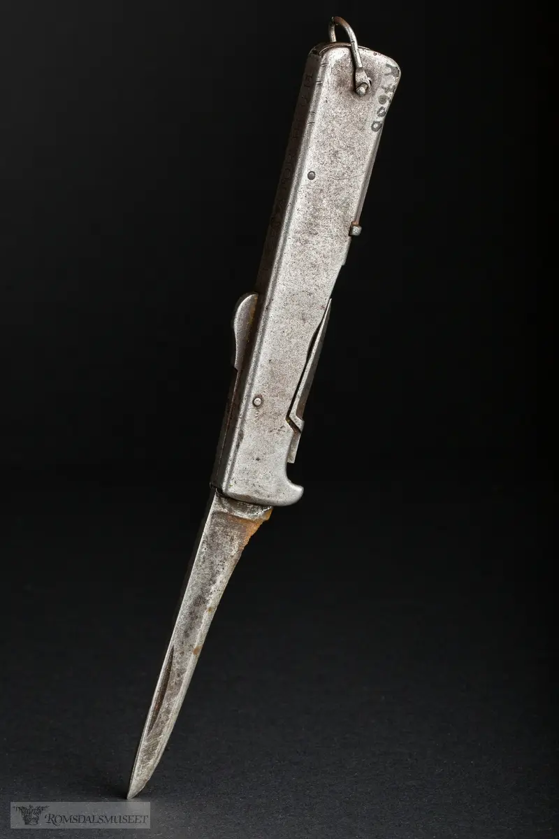 Foldbar tyskprodusert lommekniv. Kniven har to rom, et for hovedknivbladet, og et for en syl og en boksåpner. En liten hempe i metall er naglet fast i bakkant av kniven.