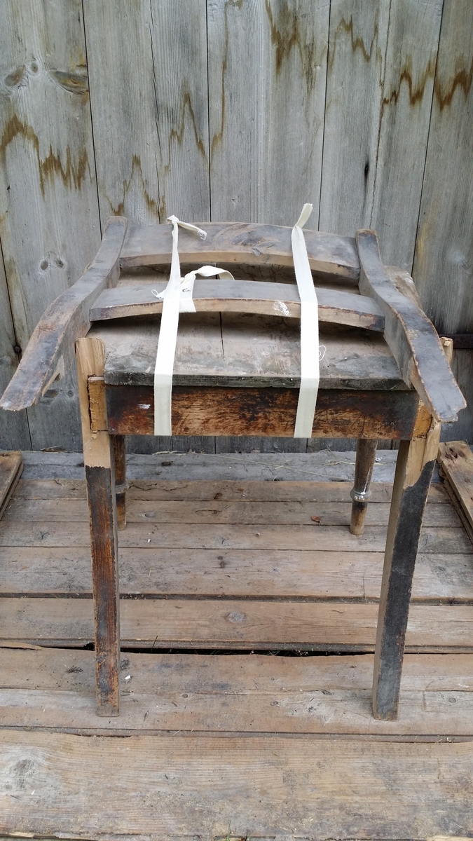 Bjørkestolen med sete i furu, er tappet, har dreide framben og svai i bakbena. Ryggstolpene er knekt ved setet.