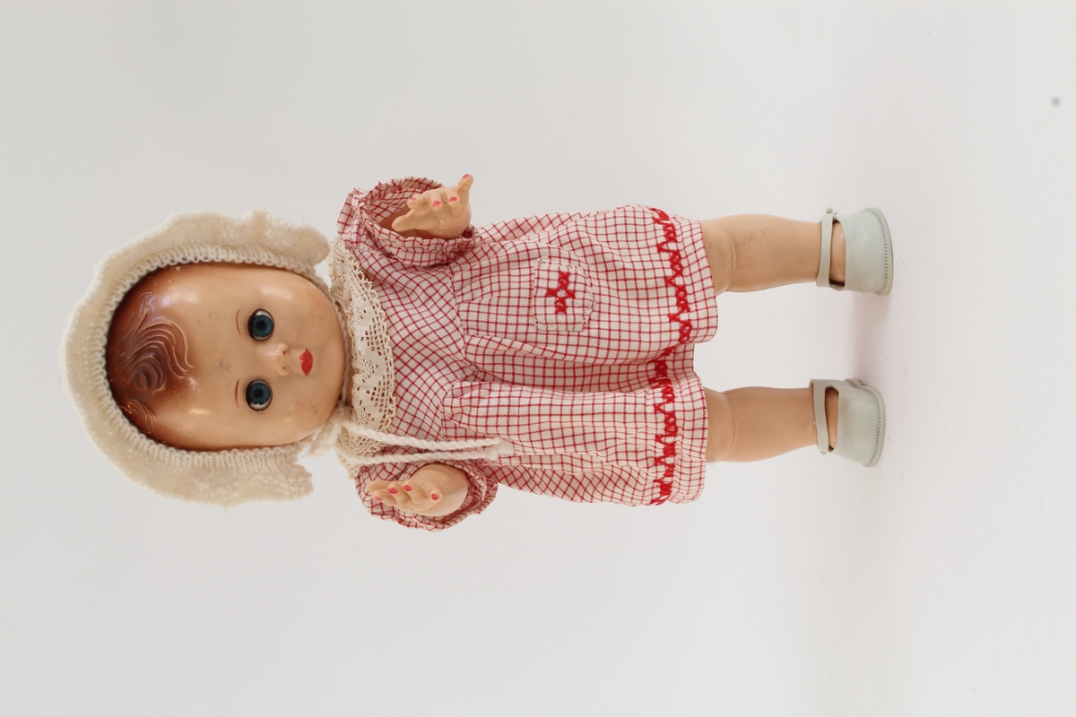 Siste eier Elisabeth Marthinsen. Gitt etter ønske fra Elisabeth til Kvinnemuseet etter hennes bortgang. Giver: datter, Heidi Graff.

Dukken er en dukke av merke "rosebud". Elisabeth hadde lette etter denne dukken i årevis. Det er ikke oppført hvor hun til slutt fant dukken eller hvor den er kjøpt. Dukken er liten, med øyne som "blunker/sover". Den har på seg en rutete kjole i rødt og hvitt, en hvit lue og grå sko. 

Da Elisabeth var 13 år og bodde i Bodø, ble hun tatt med "på ferie" til Oslo. Mor, far, bror, søster og Elisabeth reiste fra hjemmet. Elisabeth tok ikke med noen leker og fikk ikke sagt farvel til noen – verken familie eller venner. Hun fikk senere vite at " på ferie" betydde at de hadde flyttet. 

Som voksen ble det viktig for henne å få tilbake de dukkene hun hadde hatt som barn. Dette utviklet seg til å bli en hobby. Hun reiste rundt med ei venninne på markeder, antikkmesser og auksjoner for å bygge opp sin dukkesamling. Dette koste Elisabeth seg veldig med.  

Elisabeth flyttet til Kongsvinger i 1973, siden foreldrene hennes hadde flyttet hit. Hun var først husmor. Pendlet noen år til Oslo, og arbeidet så videre noen år i Kongsvinger.