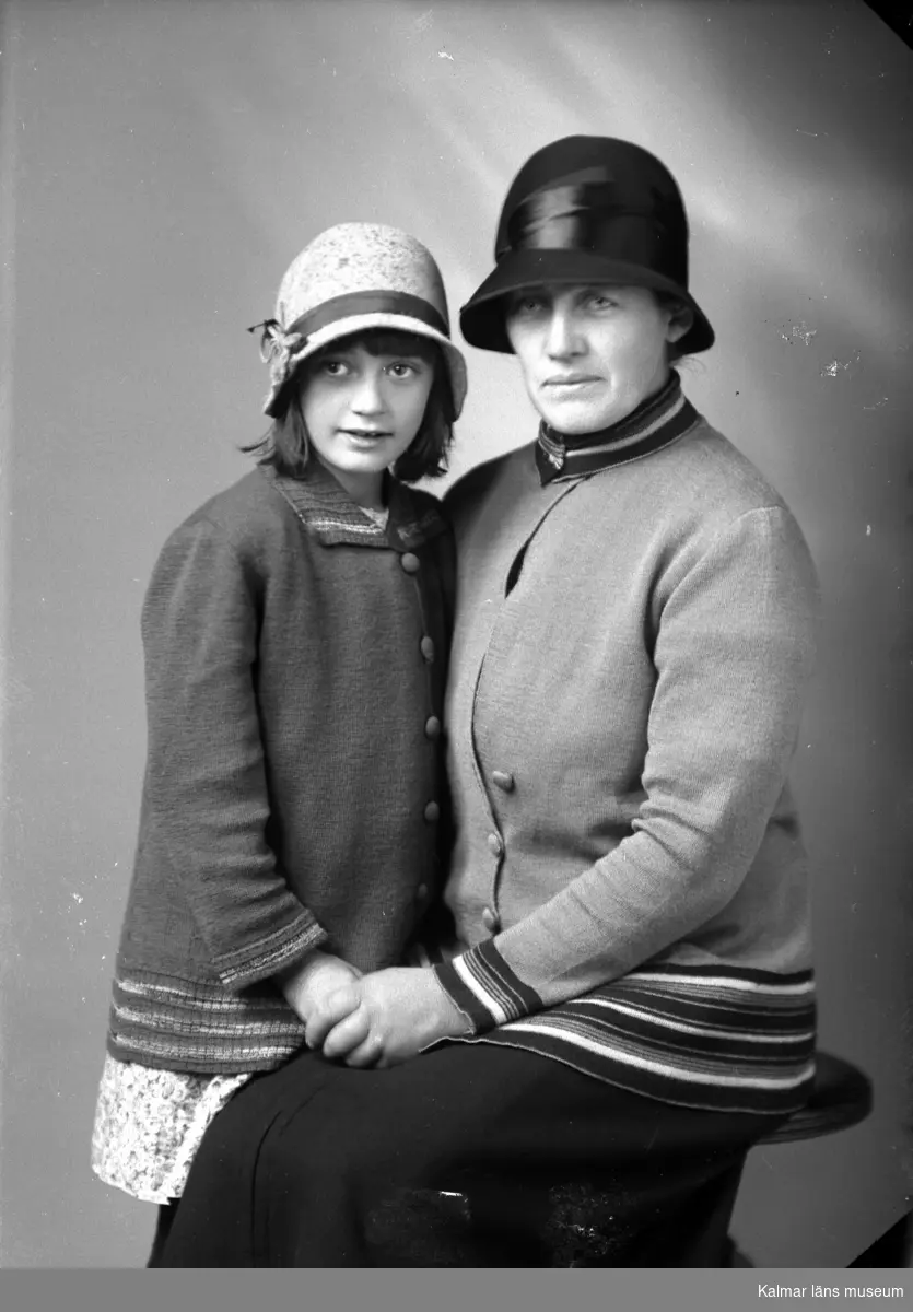 Ateljébild på en flicka och en kvinna i hatt och jacka. Beställare till bilden: Fr Mina Gustavsson ifrån Kättilstorp i Bäckebo.