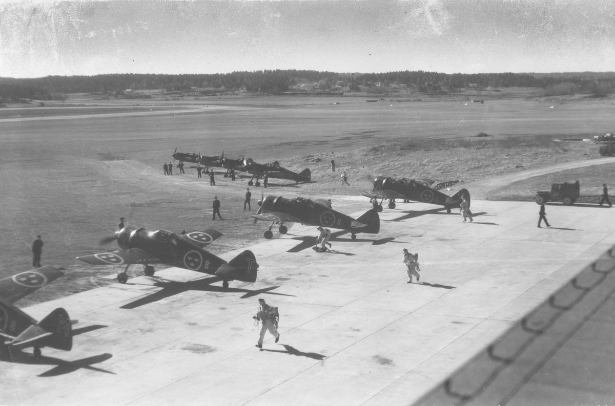 Beredskapsstart flygplan år 1945.
En jaktdivision om åtta jaktflygplan J 22 tillhörande F 8 Barkarby står på ett flygfält. Fältflygare beger sig till några av flygplanen, vilka motorkörs inför start.