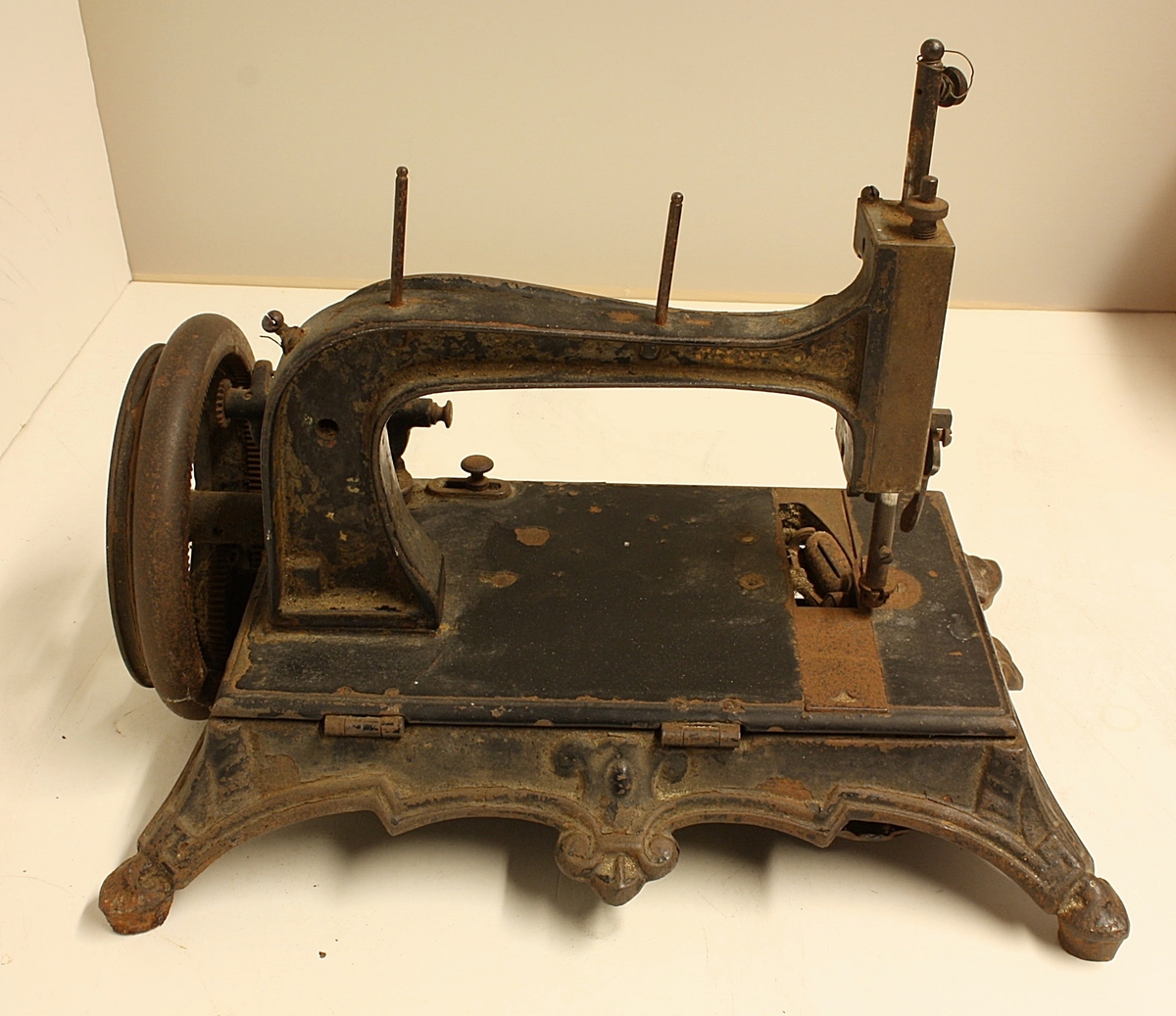 Symaskin. Opererast manuellt med sveiv. 
Tidleg modell som er liten i storleik.