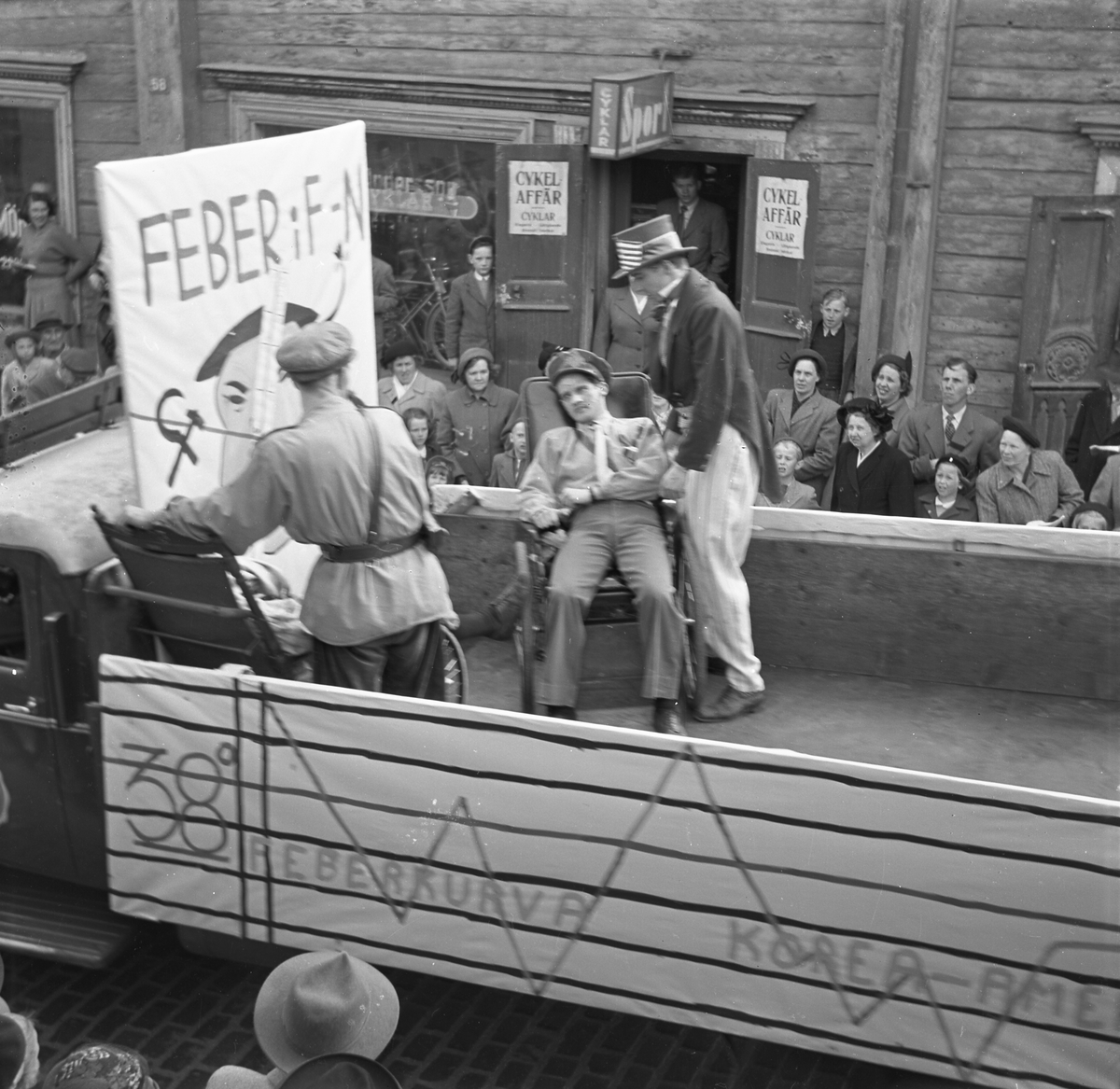 Orig. text: Majkarnevalen 1951.

Majgubbar på lastbilsflak, på Storgatan.