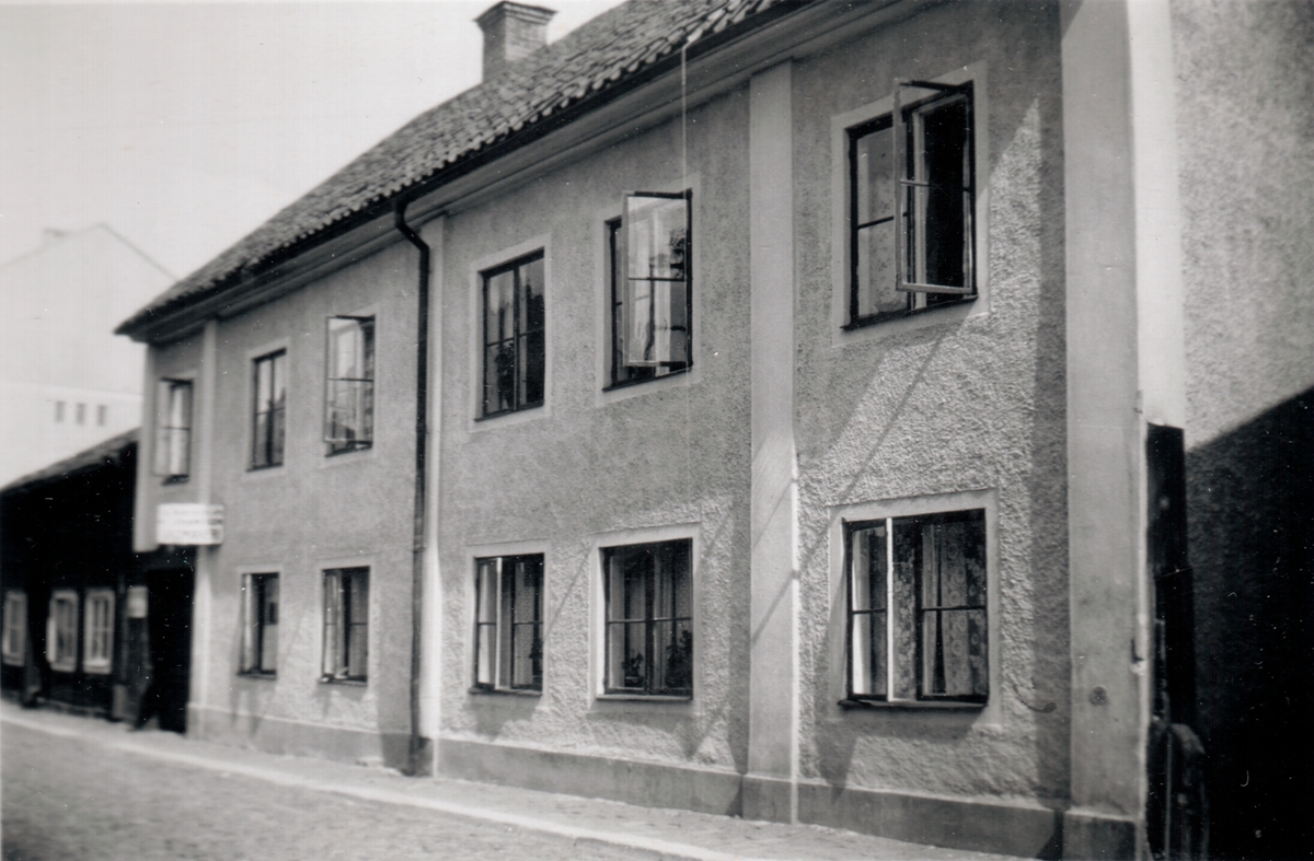Gård på Klostergatan. Wetterbergska gården: En typisk hantverkaregård från andra delen av 1700-talet. Byggherre var glasmästaren Petter Wetterberg (1740-97). Byggnaden spritputsades på 1810-talet. På 1870-talet tillkom dels verandan dels de nuvarande portarna. År 1848-59 kunde den första kvinnliga lärarinnan i staden, mamsell Johanna Charlotta Kjelland, ha skolundervisning för åttio flickor - stadens första folkskola för flickor. Byggnaden utgjorde åren 1859-63 seminariets första lokaler i staden. 1908-41 drev Föreningen Linköpings barnkrubba sin verksamhet. Byggnaden är flyttad till Gamla Linköping.
Bilden är monterad på ett albumblad. Orig. text till bilden: Hydenska gården Klostergatan 19 (troligen fel, fanns Hydenska gård vid Storgatan 41).