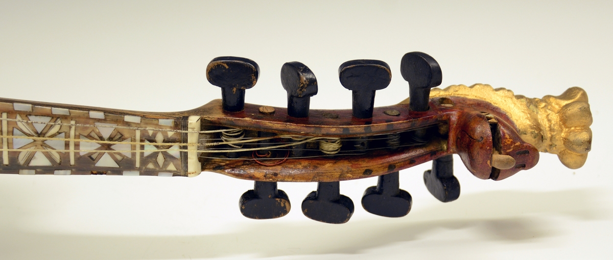 Fra protokollen: Hardingfele av den eldre, smale typen. Bruleggjingi stjerneforma, raud ferniss, stillepinnar og hovud spm vane (Hovudet nygylt). Paa merklappen inni stend: Fabrikeret af Erik Johnsen Helland i Bøe 1838. (Aarstalet ber merke av aa vera retta, serleg seinste siffer; papiret under aarstalet er vekkskrapa og talet uppnya paa berre treet.). Lok av gran, trojsk av hegg, botn av svartor, hovud av bjørk.