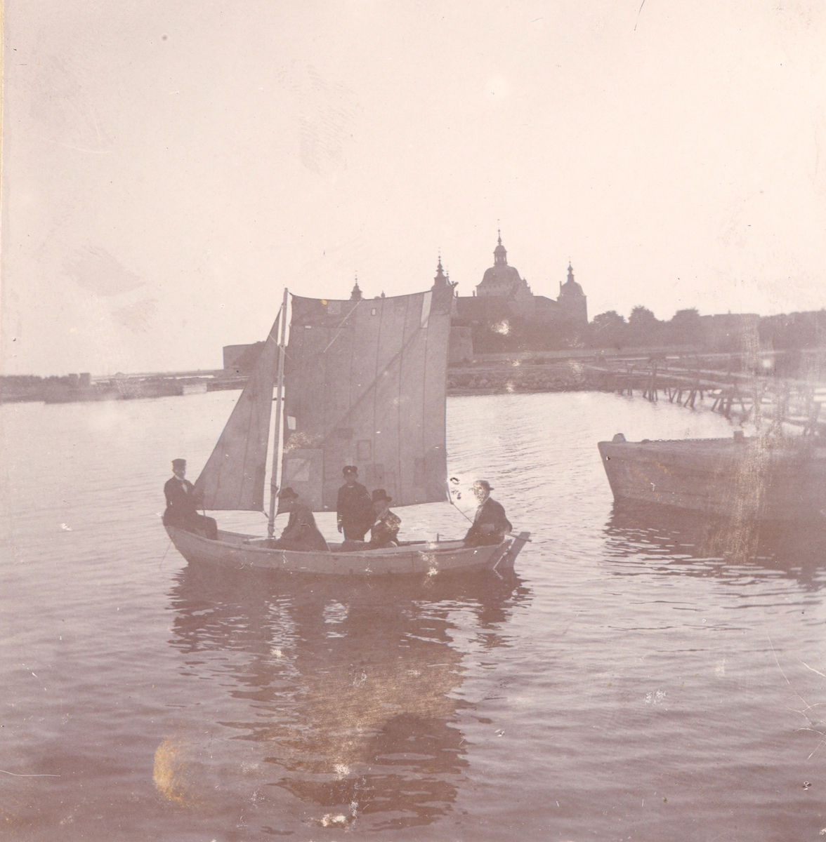 En segelbåt i slottsfjärden. Kalmar slott i bakgrunden. Troligen runt sekelskiftet 1900.