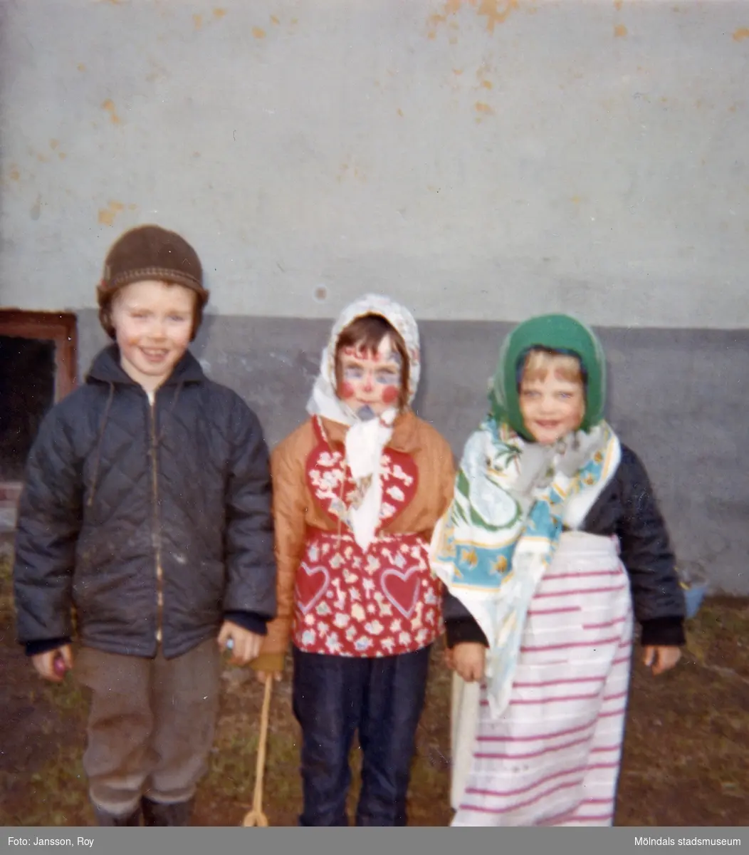 Tre påskklädda kompisar, Jörgen Larsson, Ilse Jansson och Åsa, står uppställda utefter en vägg år 1965. De bodde på Krokslättsgatan 3 i Mölndal.