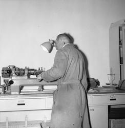 Mann i lagerfrakk på ved DNZ, Zinken, arbeidsbenk, instrumen