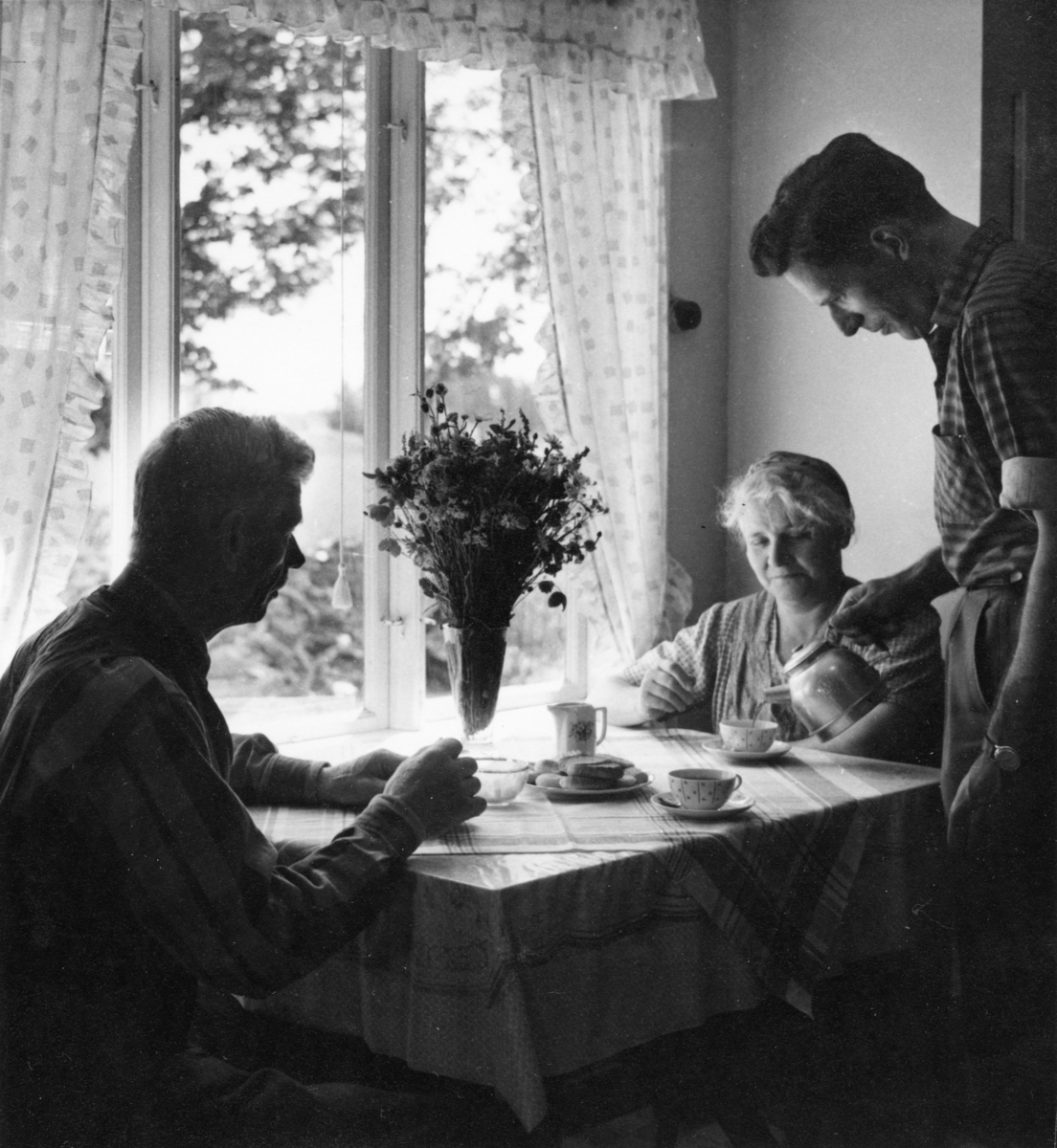 Midsommarkaffe. Stig Olsson serverar sina föräldrar Oscar och Astrid.