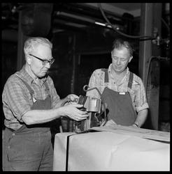 Nestor Olsen og S. E. Simonsen pakker Mg-barrer for frakt.