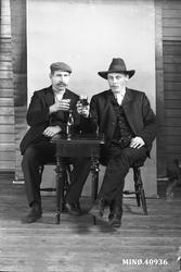 Portrett av to menn som skåler. K. Karlsen