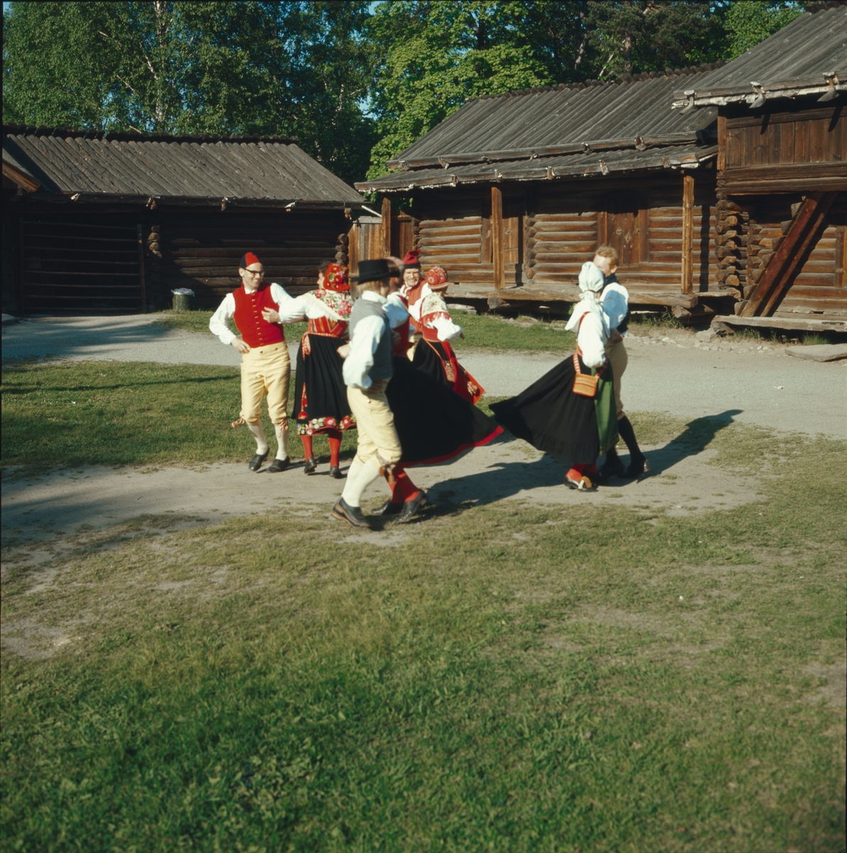 Ett folkdanslag dansar på Moragårdens gårdsplan.
