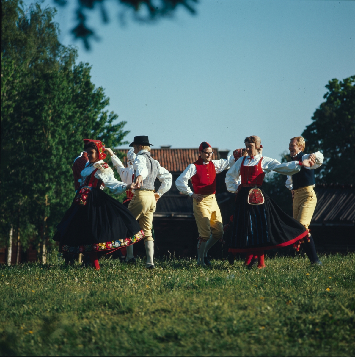 Ett folkdanslag dansar på Tingsvallens gräsplan.