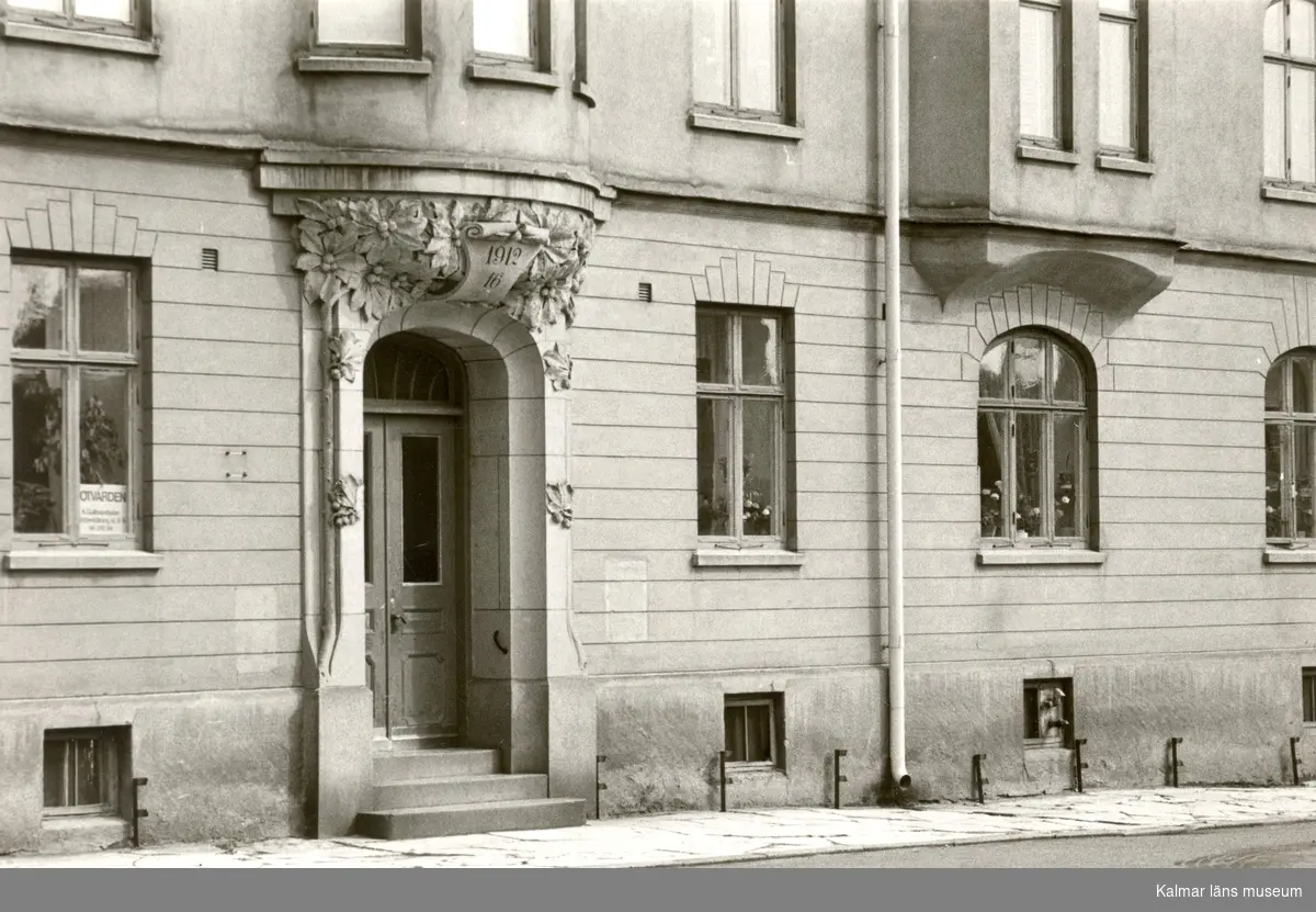 Kvarteret Framsta 5, huset ritat 1910-12 av Josef Fredrik Olson, porten huggen av Josef Anton Schmid (1873-1933). Se artikel av Gunilla Petri i Kalmar Län 1974.