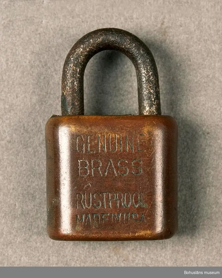 Nyckel saknas. Märkt: "Genuine Brass rustpoof. Made in USA". Mässinglås med järnbygel.