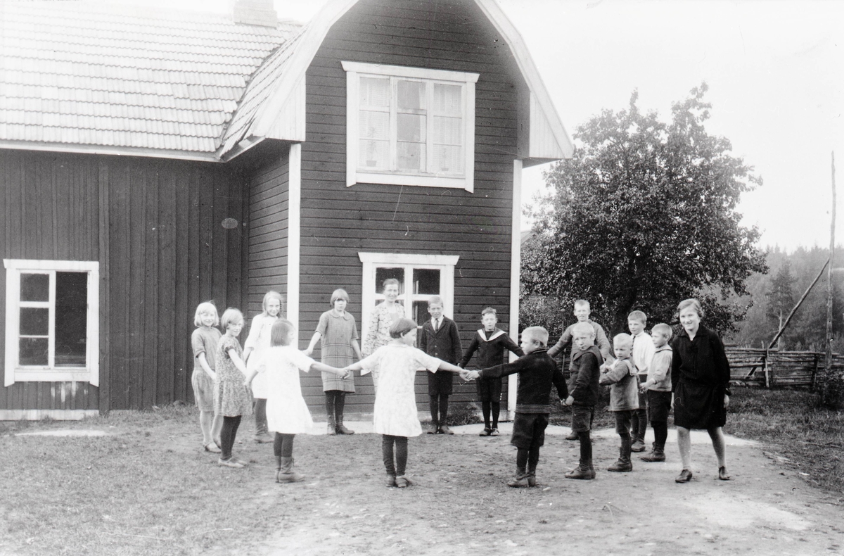 Skolbarnen och lärarinnan Ester Fransson utanför skolan år 1928.