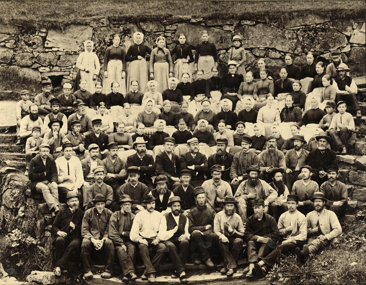 Gruppeportrett av arbeidarane ved Salhus Tricotagefabrik utanfor Bergen, i 1893. Disponent Phillip Christian Clausen og son hans Emil Clausen i midten av biletet.