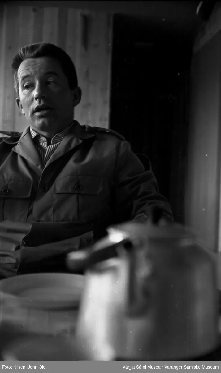 Portrett av en ukjent mann sittende ved et bord med en kaffekjele foran seg. Ukjent sted, Juli 1967.