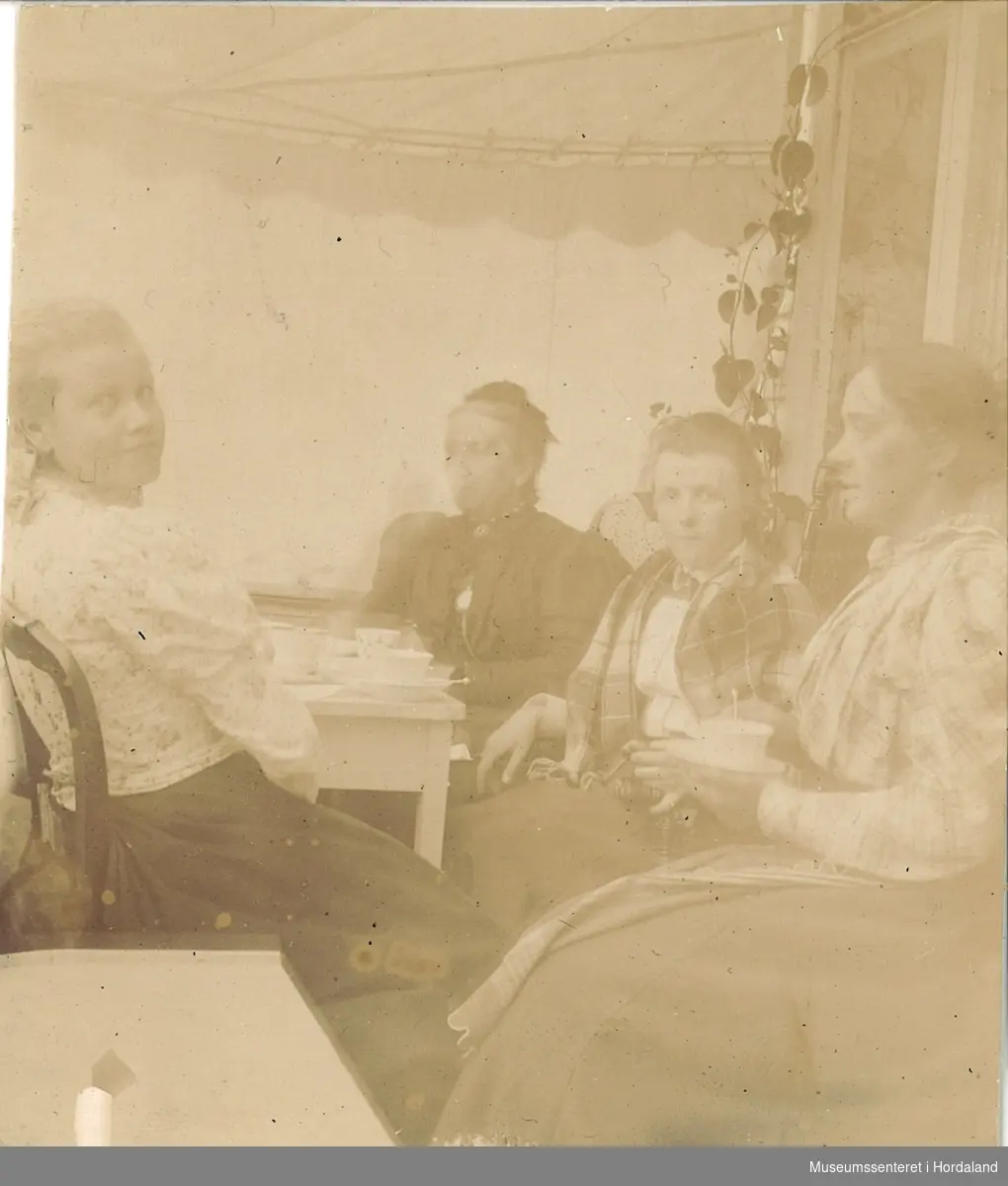 amatørfotografi av fire kvinner som sit rundt eit kaffebord. Elen Henerika Landstad er trolig nr. to frå høgre, og heilt til høgre sitt truleg Benedicte Frederike Sontum Hansen.