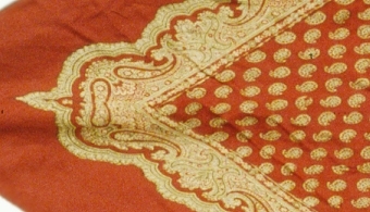 Halskläde av rött siden med tryckt "persiskt" mönster i beige färgton.


Neg.nr: 84-12