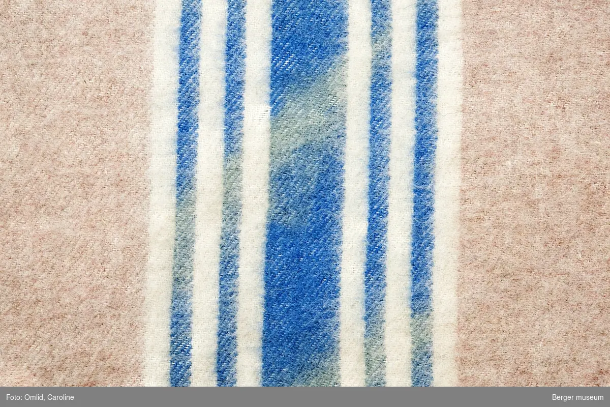 En prøve. Ensfarget gammelrosa med en bred blå stripe med to smalere striper på begge sider av den brede og hvite offwhite striper i mellom og utenfor de blå.
