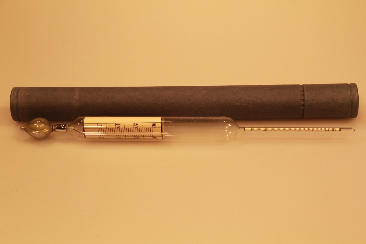 Måleinstrument med kvikksølv, for verdier i melken ved 15,5 grader. Det har en sylindrisk form med innsnevring to steder. Instrumentet ligger i original embalasje.