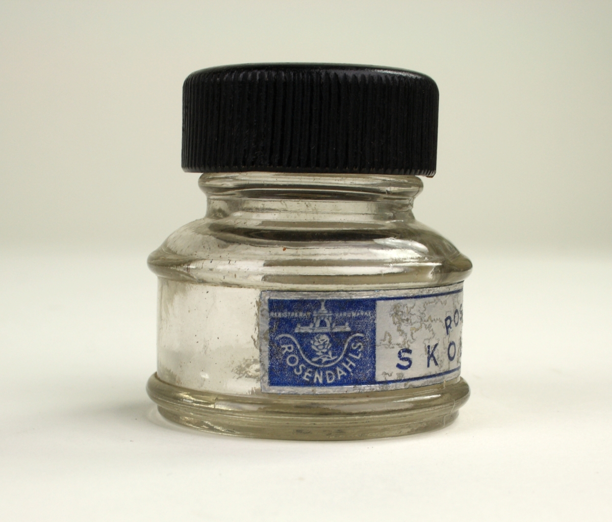 Bläckflaska av glas med ett skruvlock i svart bakelit.